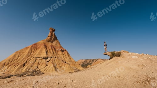 Preview: A traveler admires and photographs the magnificent Castildetierra formation in Bardenas Reales,