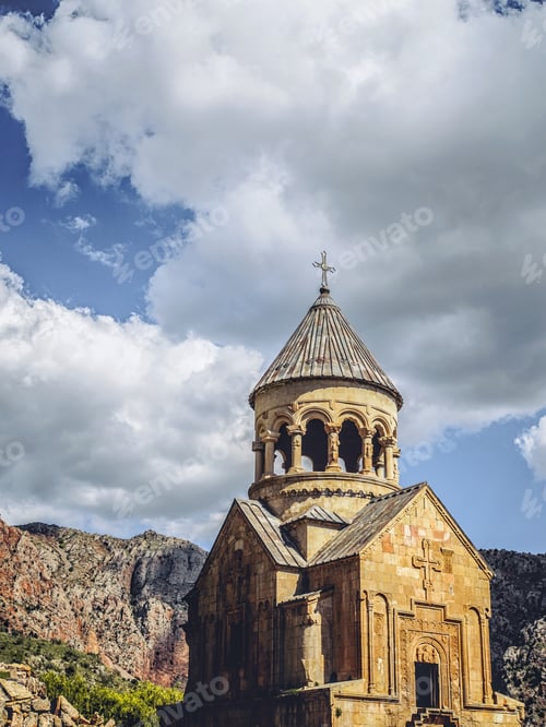 Preview: church tower in front of mountains and clouds