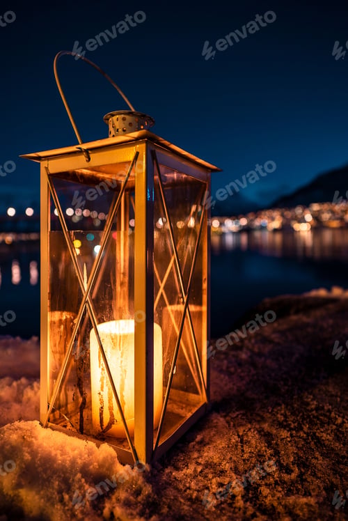 Preview: Vertical closeup of a lantern candle on a stone surface with the night cityscape in the background