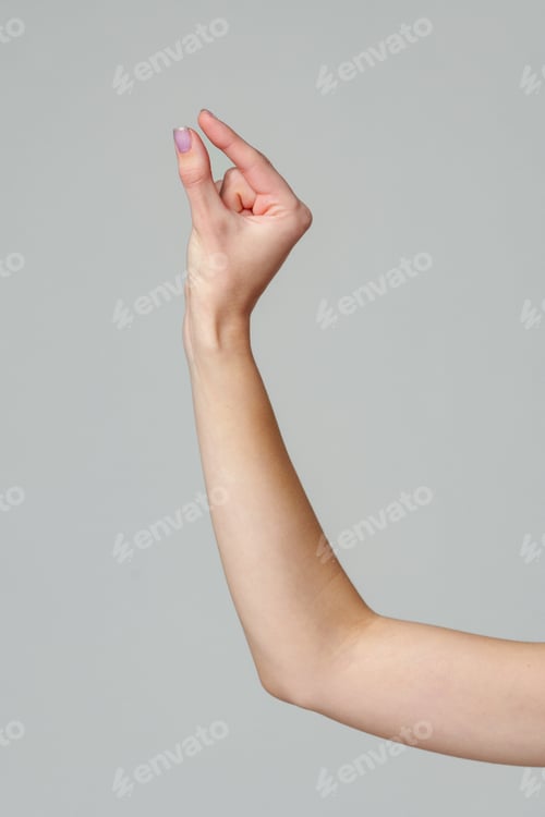 Preview: Female hand sign against gray background in studio