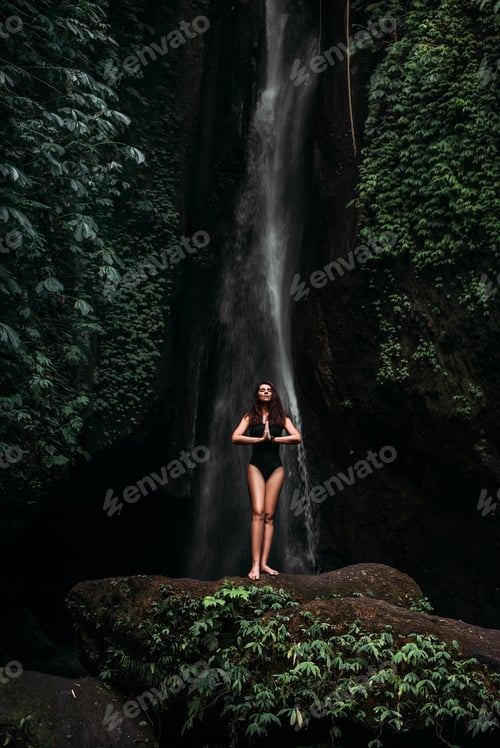 Preview: A woman does yoga at a waterfall. Healthy lifestyle. The concentration of the body