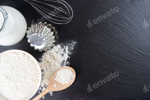Preview: Baking Ingredients Flour, Eggs, Milk, Bakeware On Black Slate Background With Copy Space