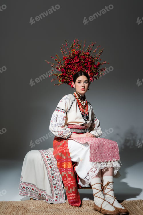 Preview: full length of pretty ukrainian woman in traditional clothing and red wreath with flowers and
