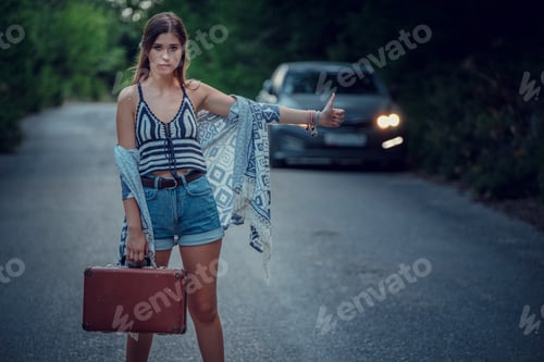 Preview: Pretty young woman hitchhiking along a road.
