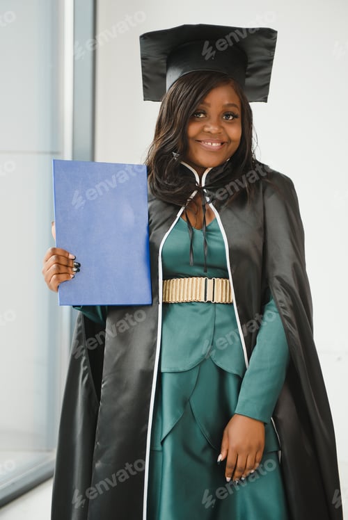 Preview: Happy Indian university student in graduation gown and cap holding diploma certificate