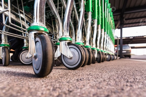 Preview: Lines of metal supermarket trolleys in a food store.