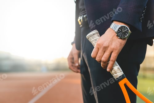 Preview: Businessman hand holding tennis racket