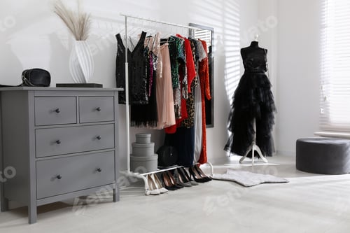 Preview: Rack with collection of beautiful festive clothes in stylish room interior
