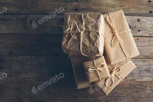 Preview: Wrapped gifts with twine on a rustic wooden table for special occasions