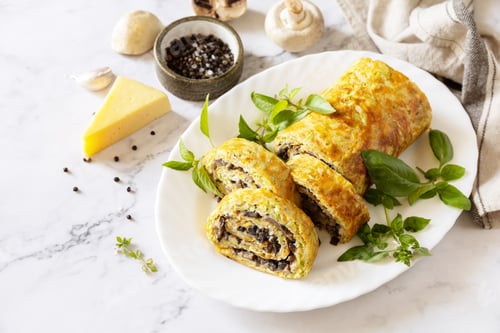 Preview: Vegetarian delicious food. Zucchini roll with cheese and mushrooms on a marble tabletop.