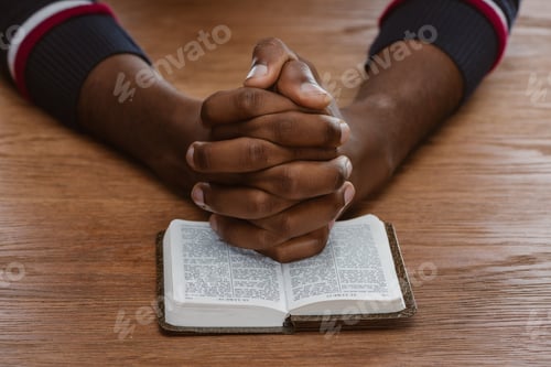Preview: cropped shot of african american man praying with holy bible