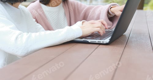 Preview: Friends using notebook computer at outdoor coffee shop