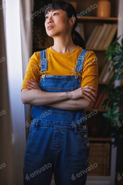 Preview: Woman looking out the window and relaxing at home