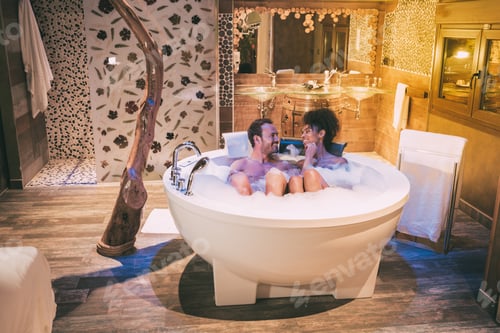 Preview: Happy young interracial couple relaxed enjoying their self in the jacuzzi
