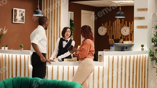 Preview: Cheerful receptionist booking in guests