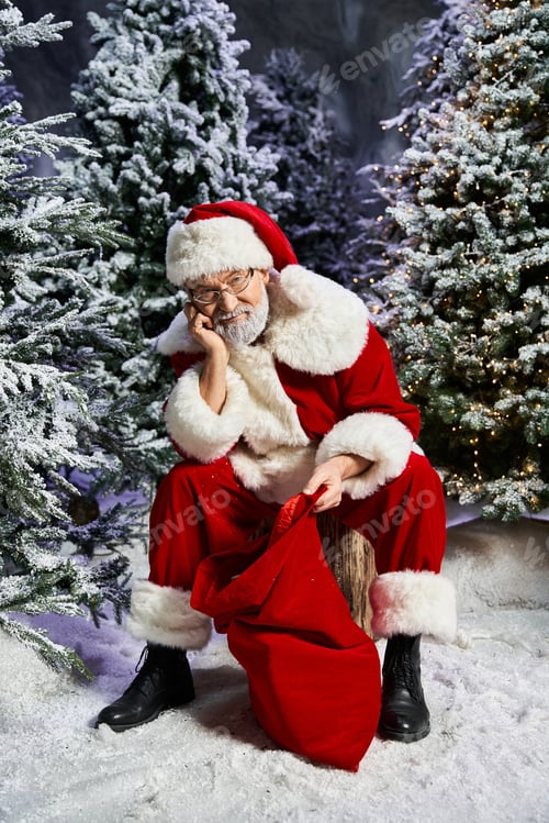 Preview: Santa Claus resting thoughtfully beside a bag of presents in a snowy forest setting