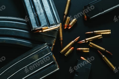 Preview: Top view of gun magazines and bullets on a black surface background