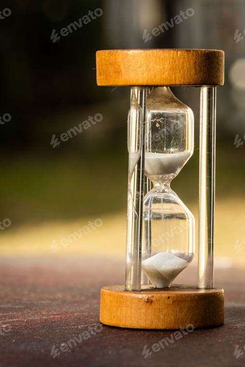 Preview: Vertical picture of an hourglass on a wooden surface