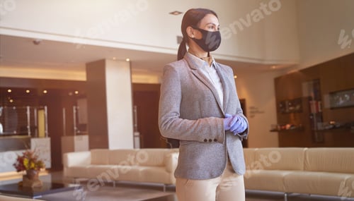 Preview: Attractive female hotel employee standing alone at work