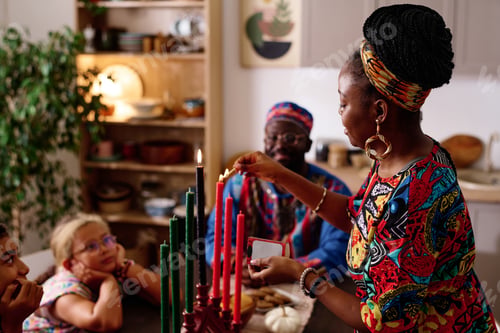 Preview: Side view of young woman burning candles symbolizing kwanzaa principles