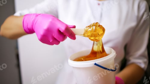 Preview: the master of sugar hair removal winds the epilation paste onto the Spatula.