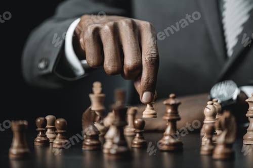 Preview: cropped shot of african american businessman holding chess figure isolated on black