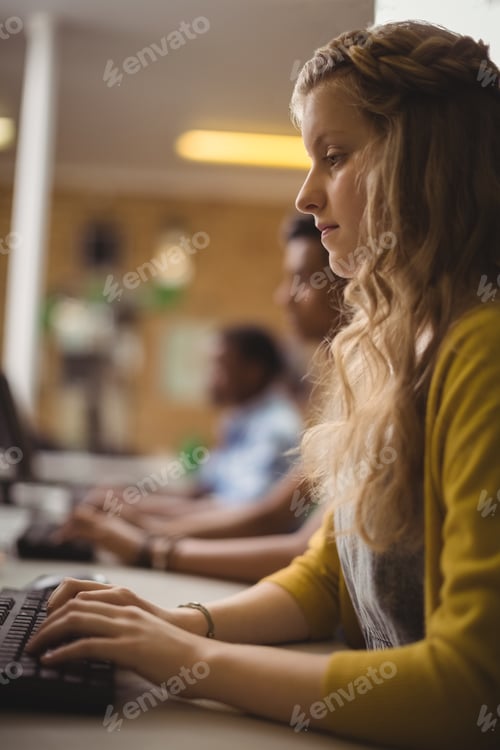 Preview: Smiling schoolgirl studying in computer classroom