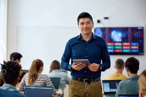 Preview: Happy high school teacher in the classroom looking at camera.