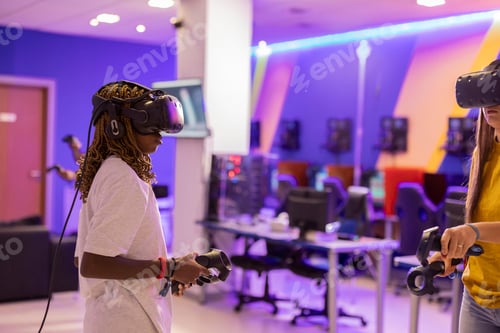 Preview: Gamers playing with virtual reality visors and controllers in a gaming room