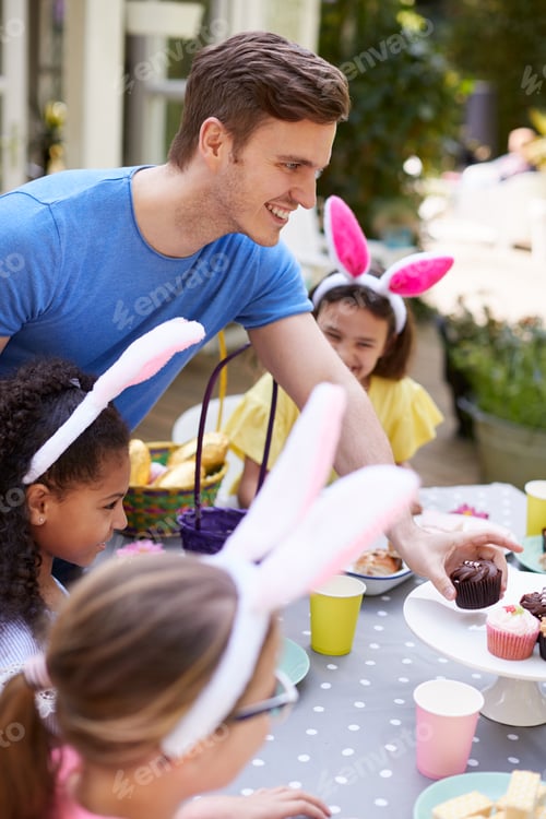 Preview: Father With Children Wearing Bunny Ears Enjoying Outdoor Easter Party In Garden At Home