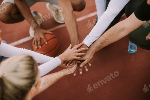 Preview: Top view of basketball team holding hands over court