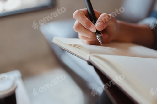 Preview: Female hand close-up writes with a pen in a blank notebook.she writing a daily lifetime.Business wom