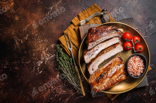 Vista previa: Chopped BBQ pork ribs on a plate with herbs. Dark background. Top view. Copy space
