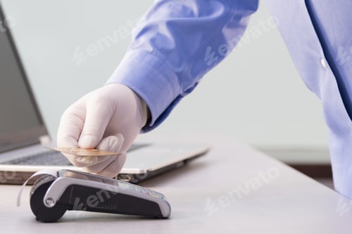 Preview: Male hand with a glove holding a credit card over the reader