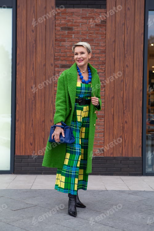 Preview: Full-length portrait of fashionable adult woman in long green coat and elegant dress