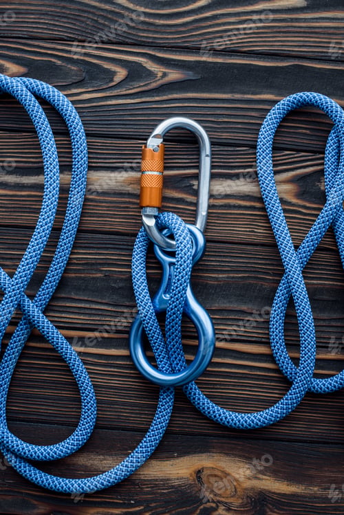 Preview: Isolated photo of climbing equipment. Parts of carabiners lying on the wooden table