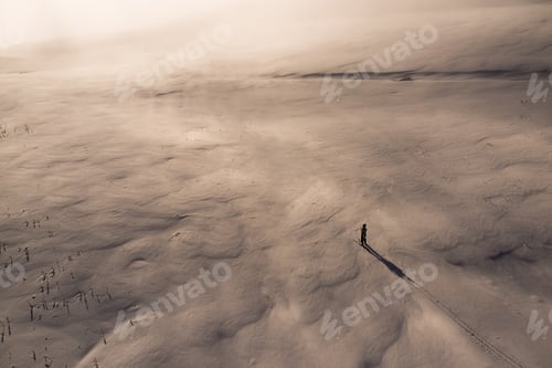 Preview: One skier in snow field at sunset view from above