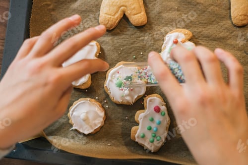 Preview: Close up of a little girl hands decorating Christmas cookies