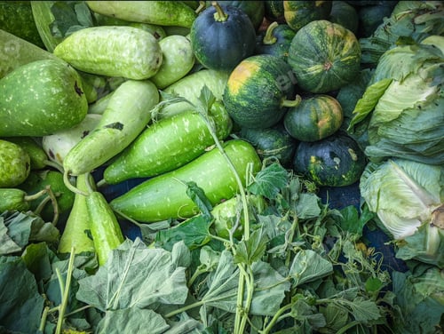 Preview: Heap of gourds, green pumpkins, and cabbage at the market