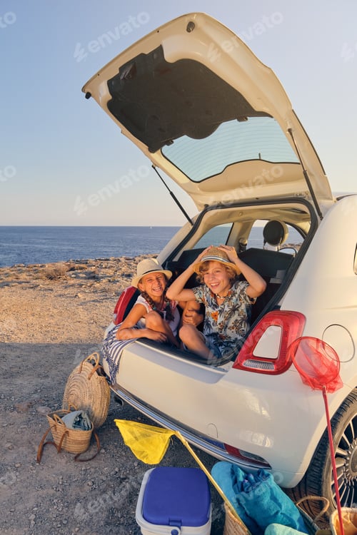 Preview: Children inside the trunk of a car making joke gestures with bas