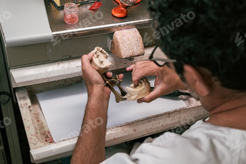 Preview: Technician preparing the articulation mechanism of a dental prosthesis
