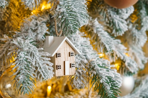 Preview: Snowy Christmas Tree Branch With Wooden House Ornament And Warm Golden Holiday Light Illumination