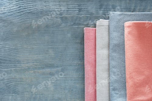 Preview: Different colorful napkins on wooden table, top view. Space for text