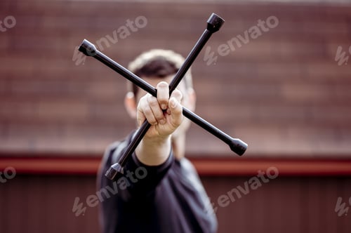 Preview: Closeup shot of a man holding a metallic tool for installing a wheel