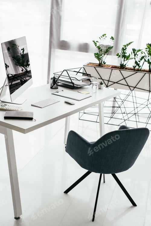 Preview: white table with computer, notebook, document tray, glass near office chair and flowerpot with plant
