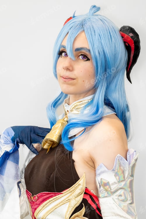Preview: Female cosplayer with blue hair and an elaborate dress posing against a neutral background