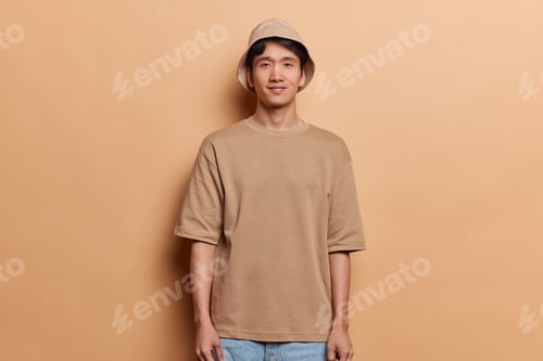 Preview: Horizontal shot of handsome Japanese man with dark hair dressed in casual t shirt jeans and panama