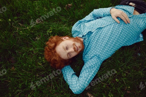 Preview: Portrait of a ginger man relaxing on the grass