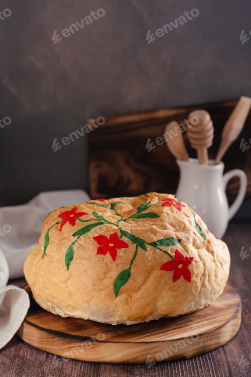 Preview: Loaf of bread hand painted with edible paints on a wooden board vertical view