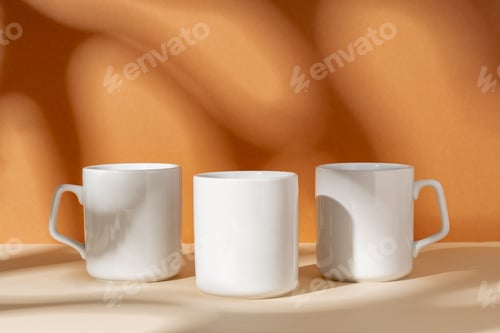 Preview: White ceramic mugs on peach background with shadows
